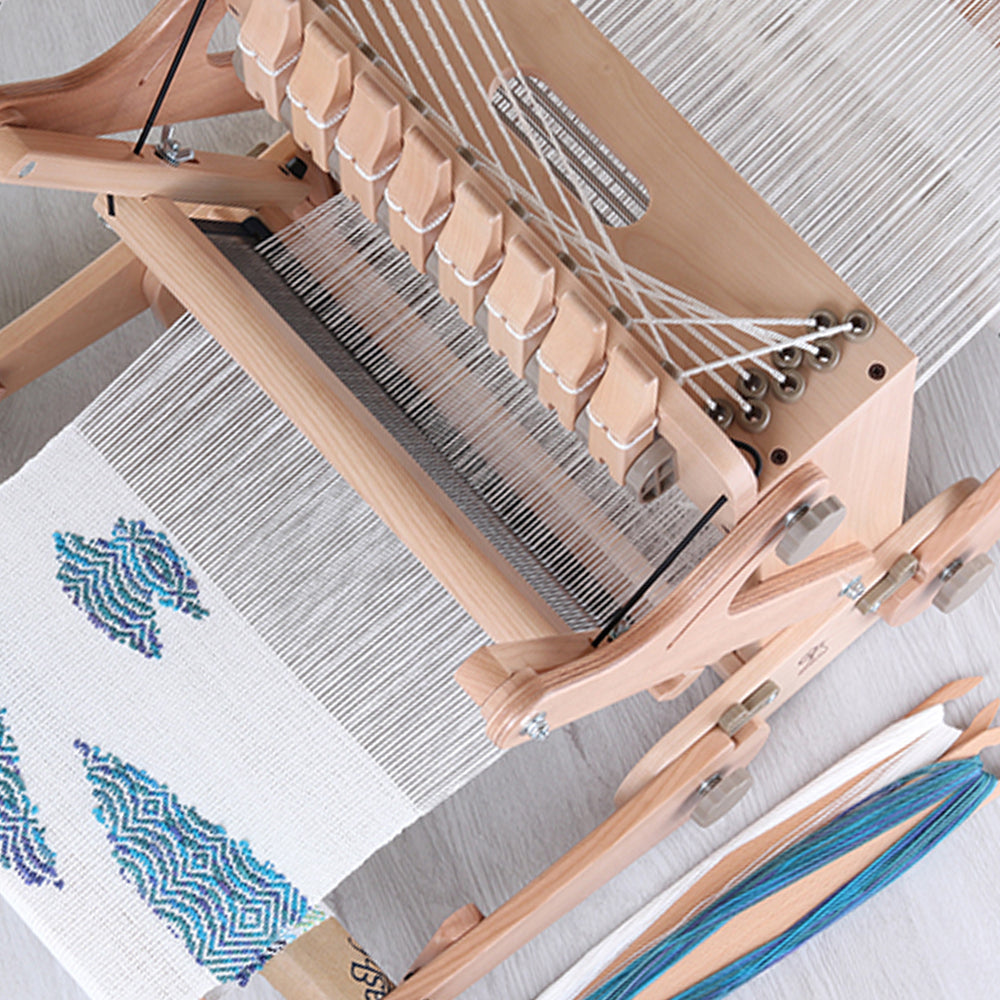 Métier Ashford Table Loom 8 cadres avec une navette en bois sur la chaîne tendue